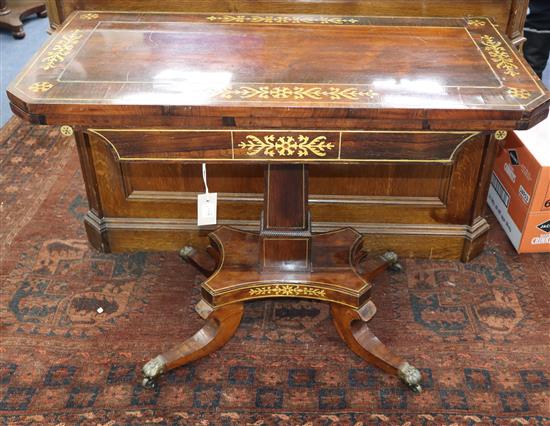 A Regency rosewood card table inlaid with cut brass-work, on square pillar and quadripartite base (damage) W.92cm